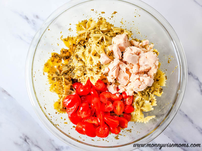 adding chicken to bowl with tomatoes