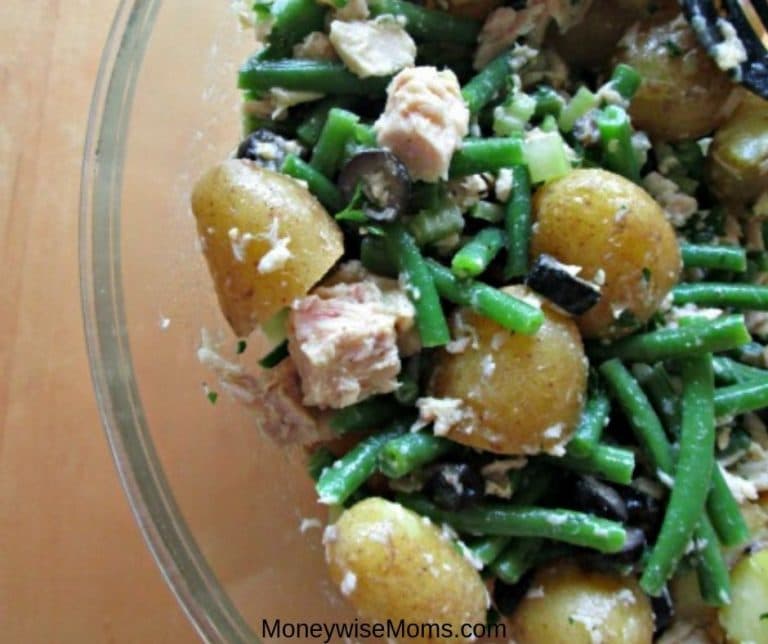 Close up of the finished salad recipe in a bowl showing tuna, green beans, and potatoes with dressing.