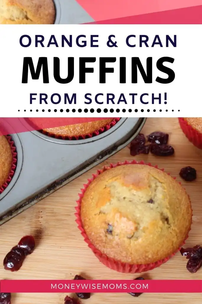 baked orange cranberry muffins in muffin tin on wooden cutting board