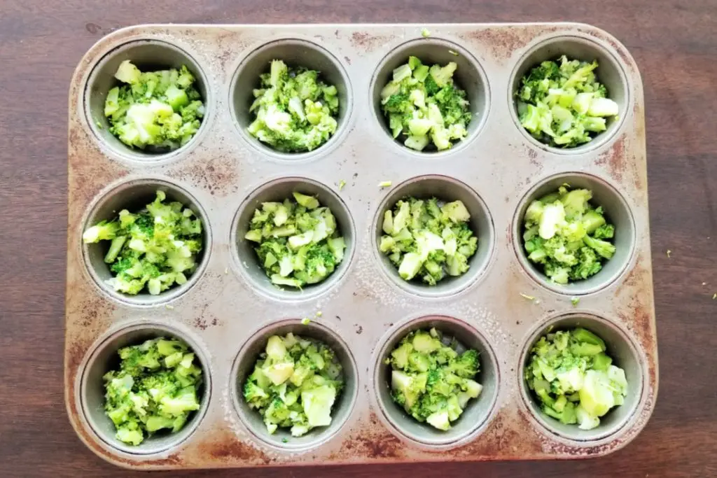 Add chopped broccoli to muffin tin