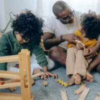 African American man playing with kids at home