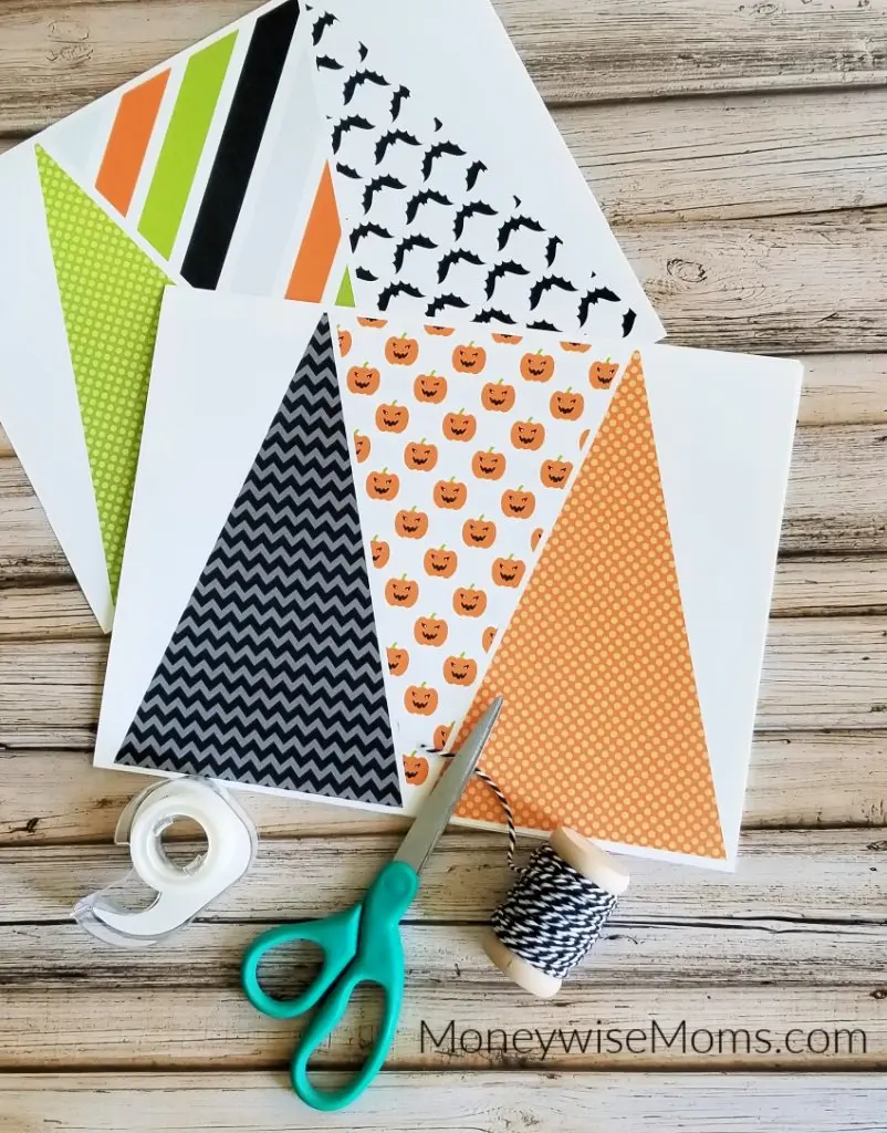 paper flags string tape and scissors to make Halloween bunting