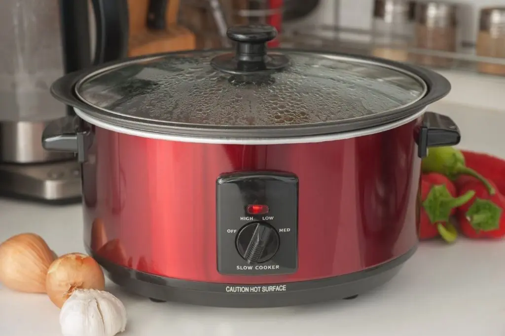 Red crockpot slow cooker on kitchen counter