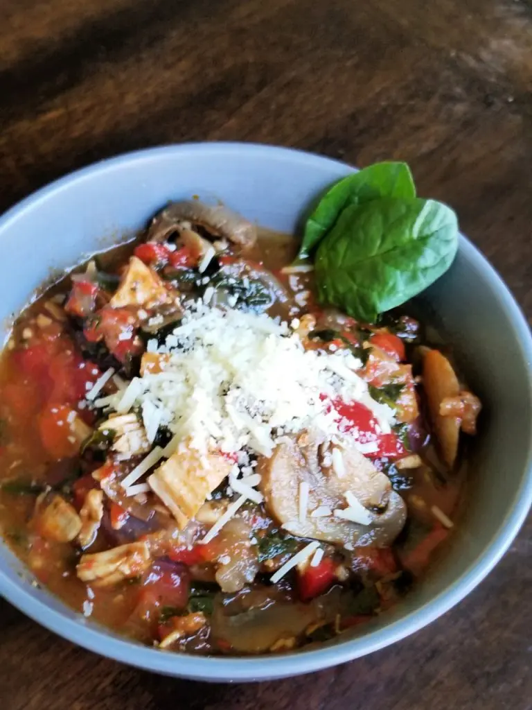 Tuscan Chicken Soup in a gray bowl on brown table