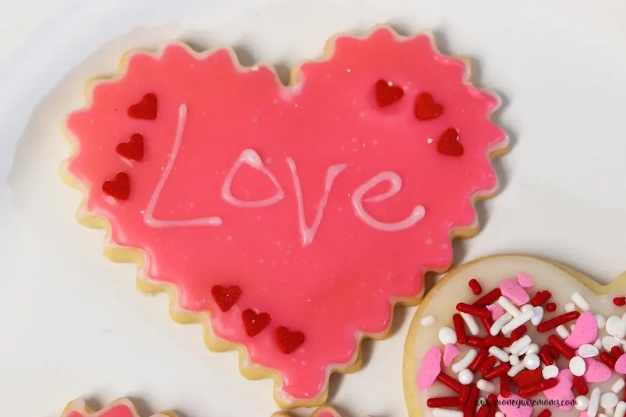 here we see a valentine heart cookie with the word love written on it. 