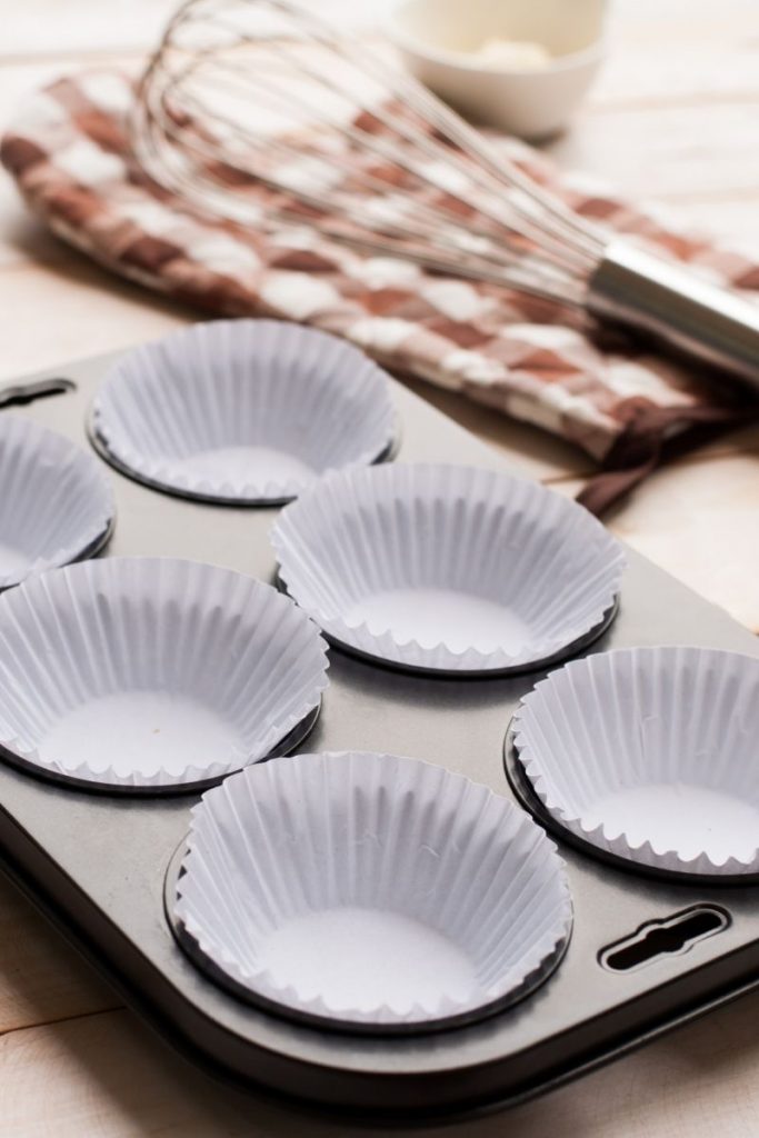 Empty muffin tray with white cupcake liners