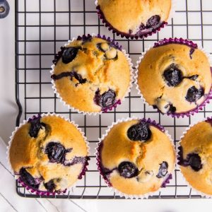 blueberry muffins on cooling rack on marble countertop