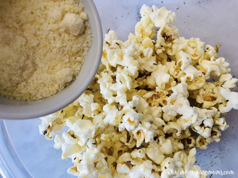 Parmesan cheese being added to the popcorn.