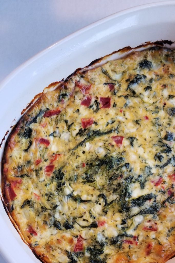 Baked italian spinach pie in white oval casserole dish