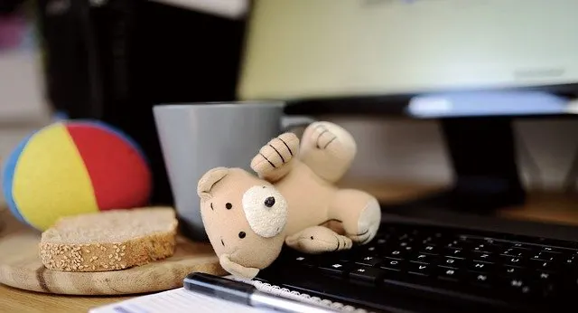 computer keyboard with teddy bear piece of bread mug and ball