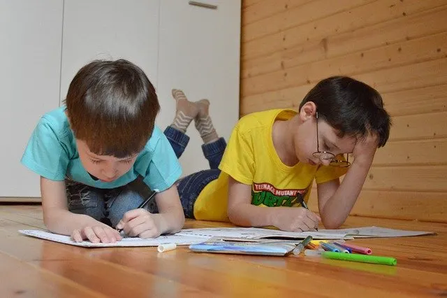 Two boys lying on floor coloring