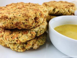 Finished easy recipe for salmon patties next to dill mustard dipping sauce.