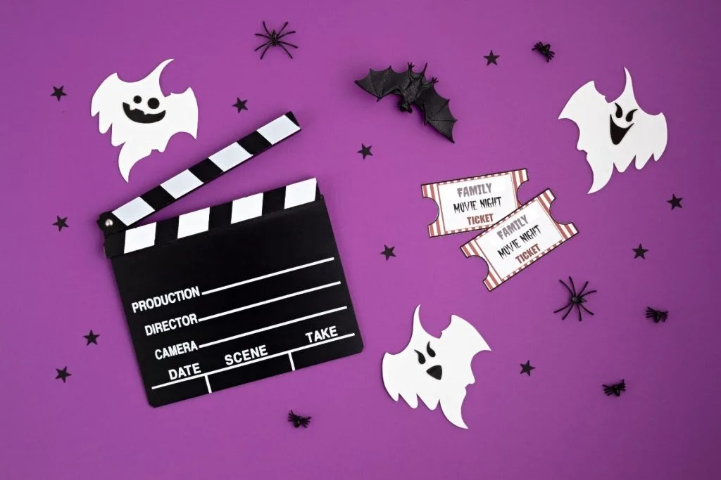 Family movie night tickets with Hollywood clapboard and ghosts on purple background