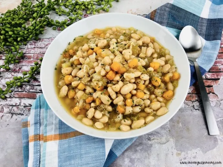 Featured image showing finished slow cooker bean soup in a white bowl ready to eat