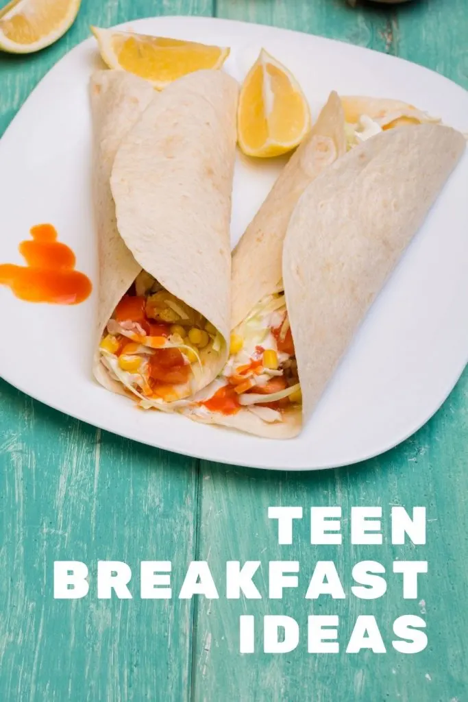 breakfast burrito on white plate on green table