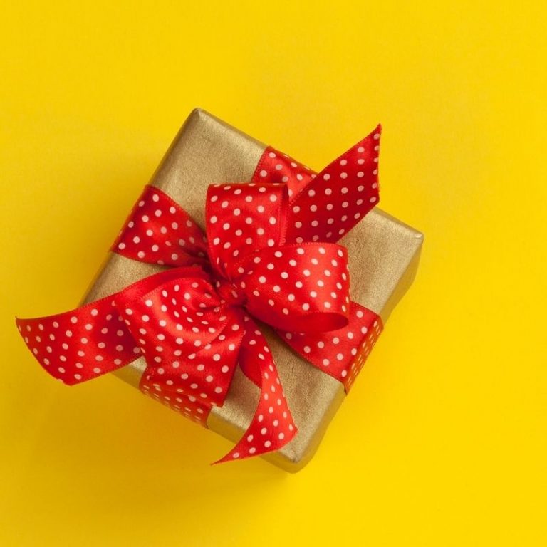brown gift with red ribbon on yellow background