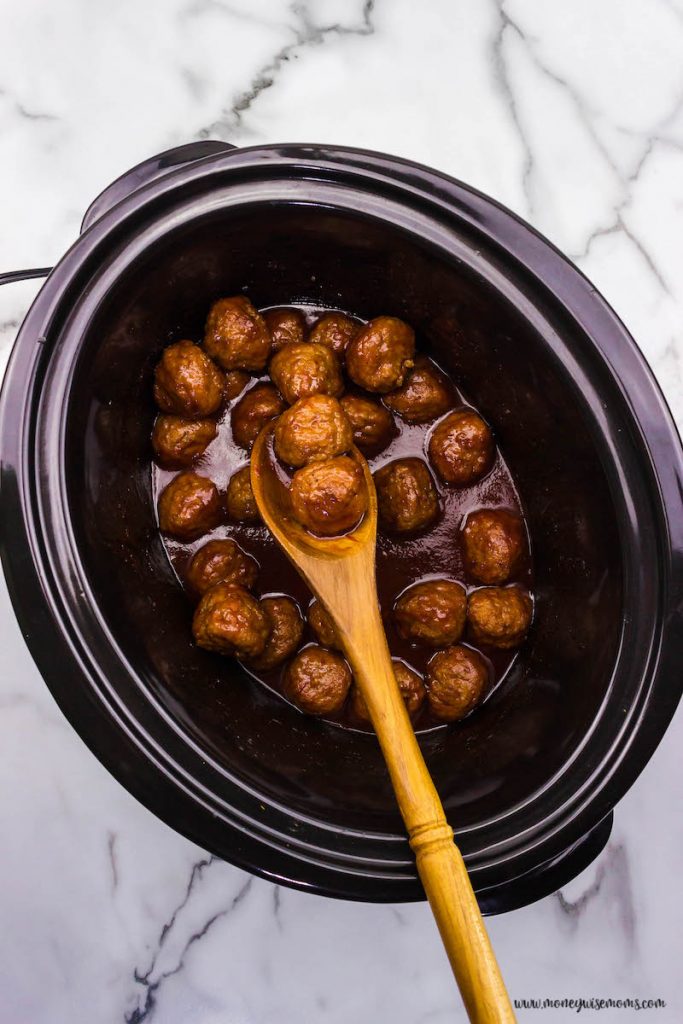 finished meatballs on a spoon in the crockpot