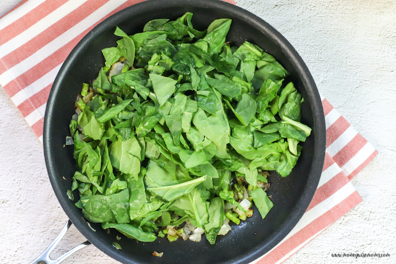 spinach being added to the hot pan. 