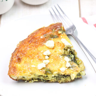 slice of vegetable frittata on white plate with fork
