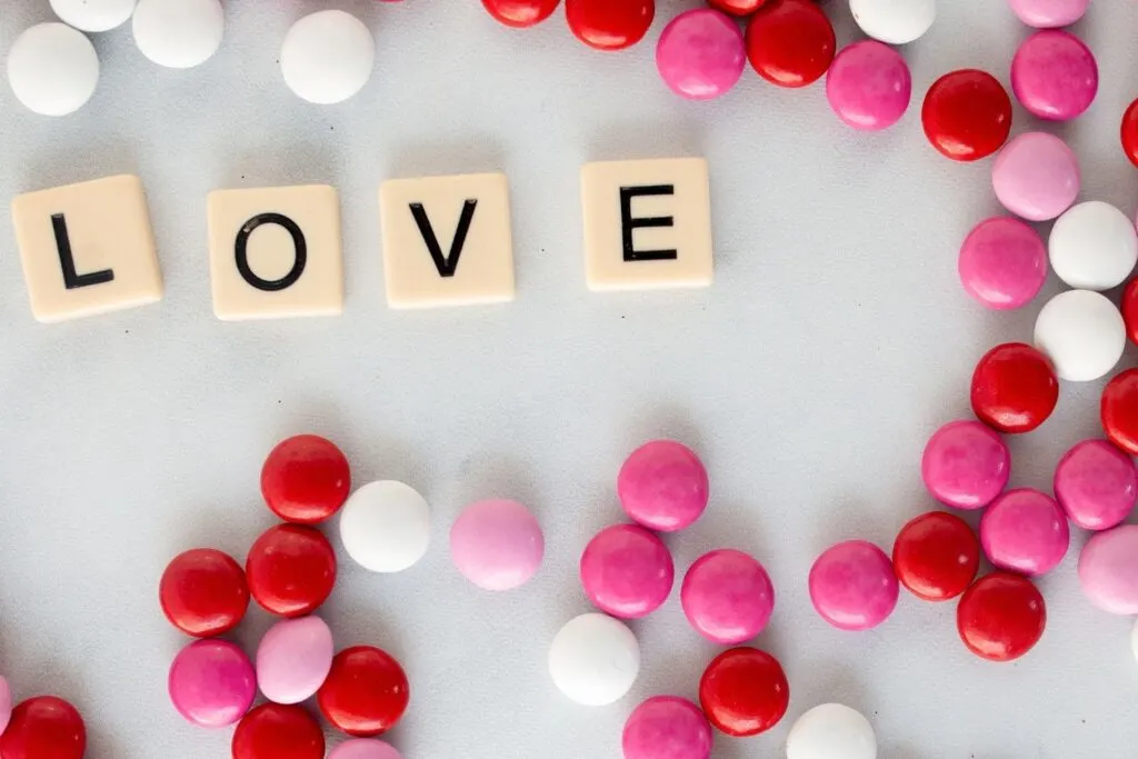 red white and pink M&M candies with scrabble tiles spelling LOVE