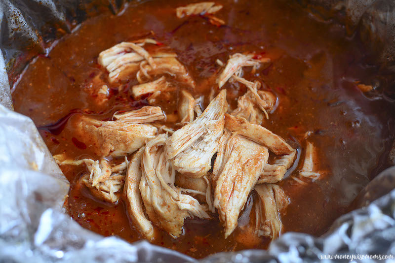 chicken cooking in red enchilada sauce