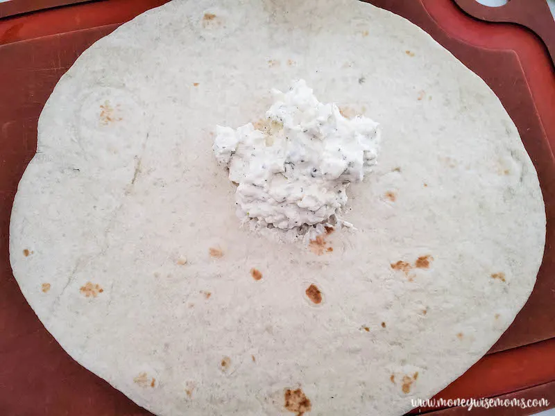 cream cheese mixture being spread on tortillas.
