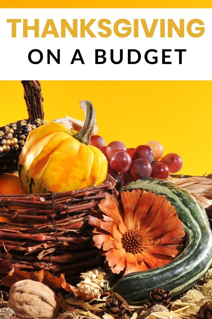 Thanksgiving on a budget - basket with gourd grapes corn and squash on yellow background