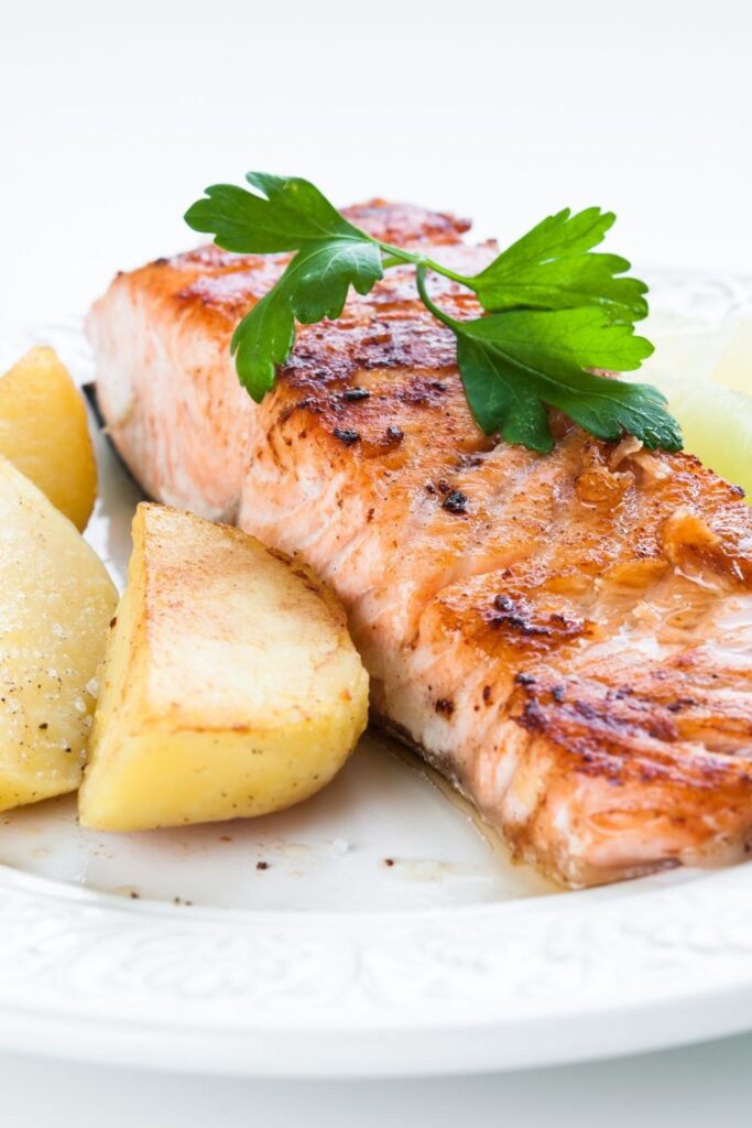 cooked salmon and potatoes on white plate