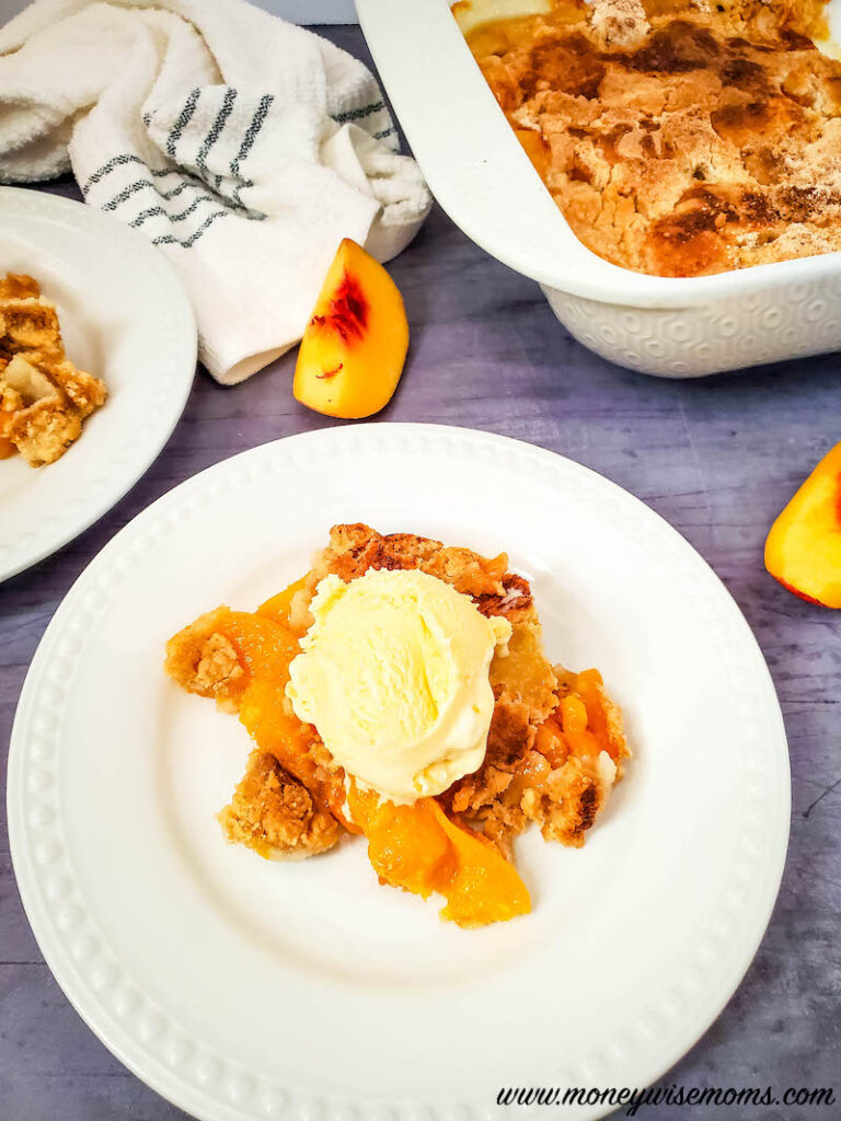 vertical image showing plate of finished recipe for peach dump cake. 