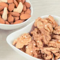 almonds and walnuts in white bowls