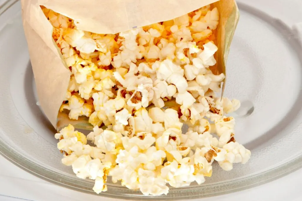 popped popcorn in brown paper bag in microwave