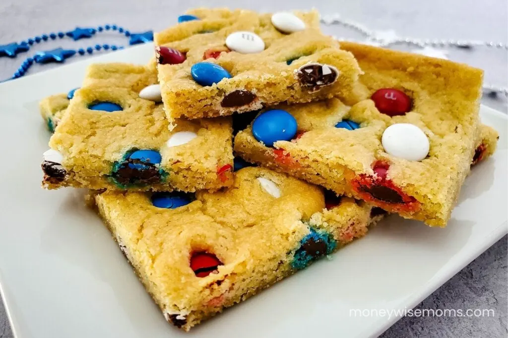 M&M cookie bars cut into squares on white plate