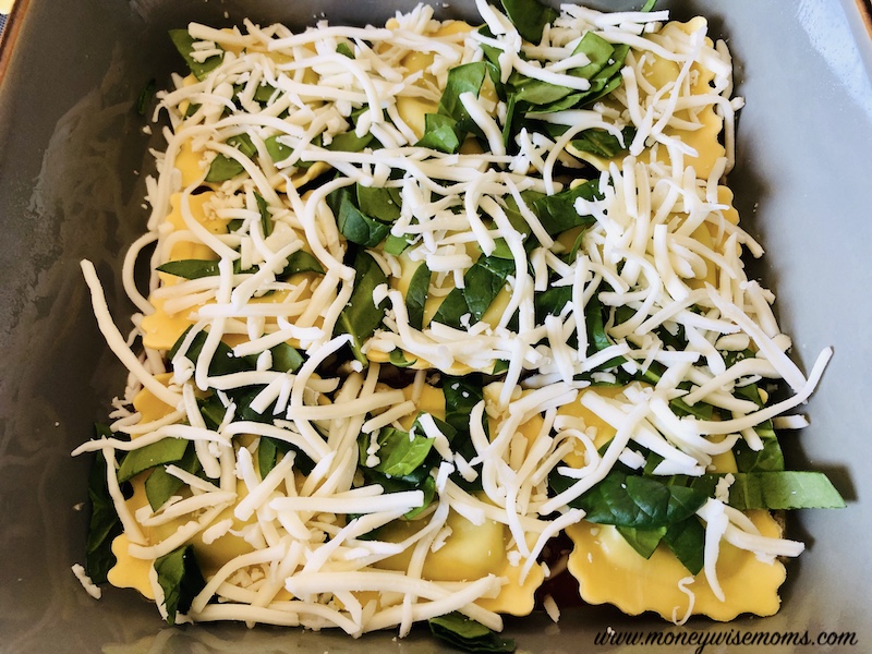 Adding spinach and cheese to the ravioli layer. 
