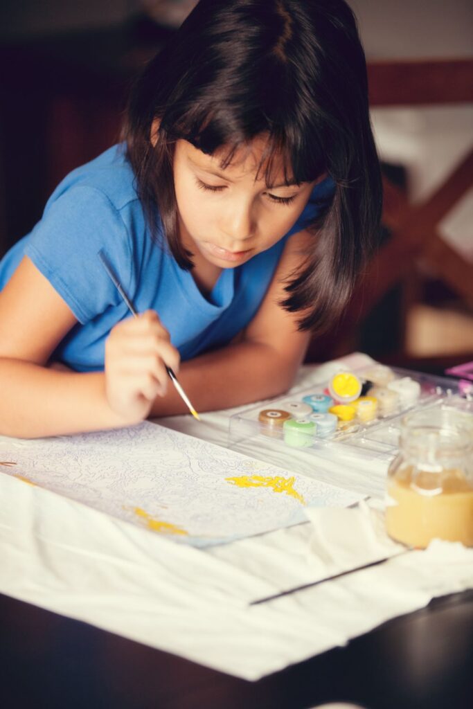 Girl doing paint by number art project - indoor summer activities for kids