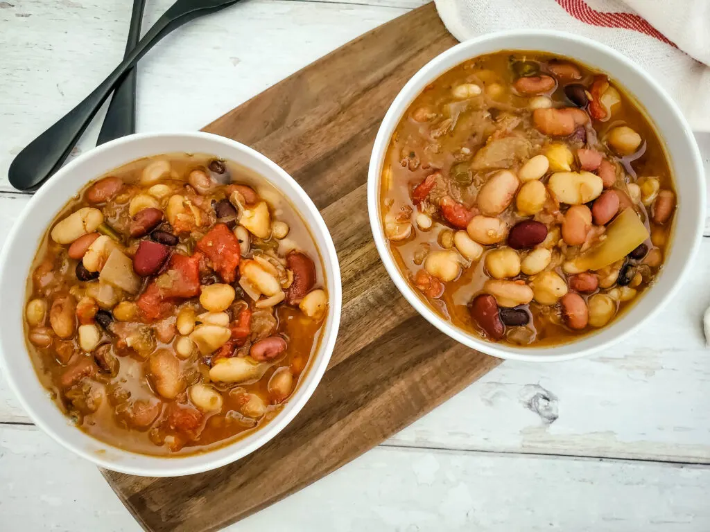 Two white bowls of bean soup made in the slow cooker