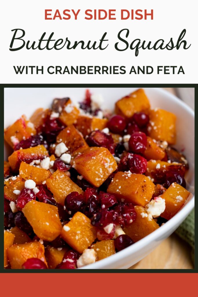 white bowl of roasted butternut squash cubes with feta cheese and cranberries