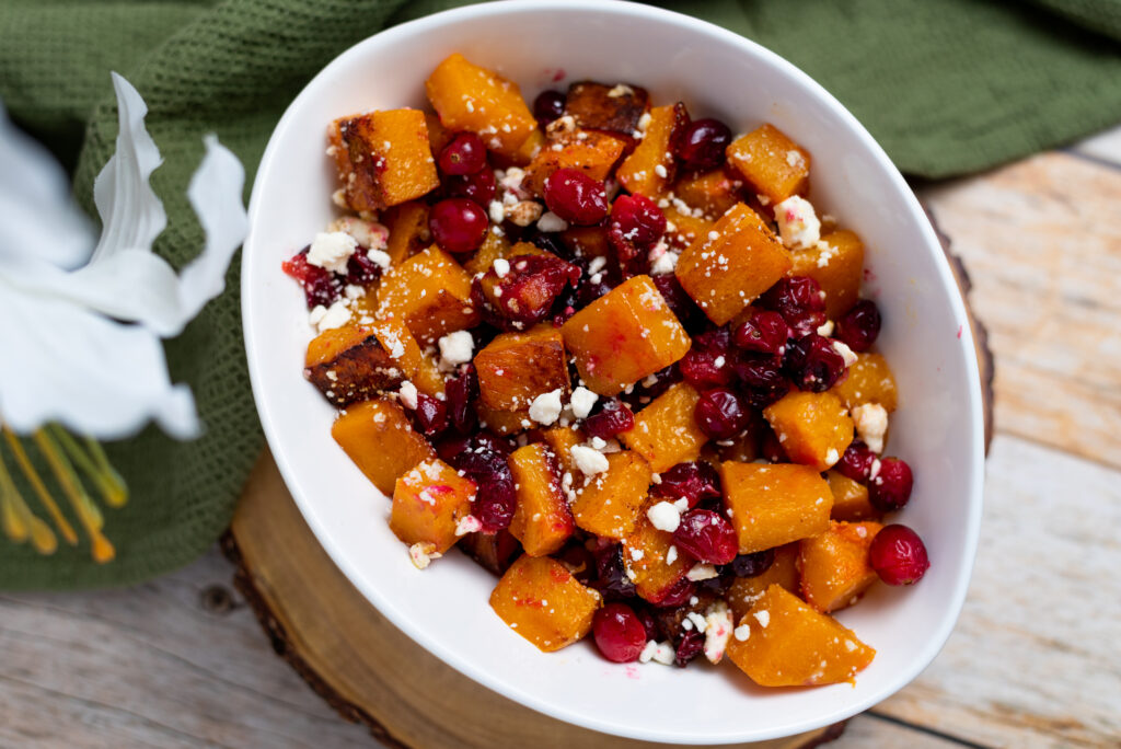 White bowl of roasted butternut squash with cranberries and feta