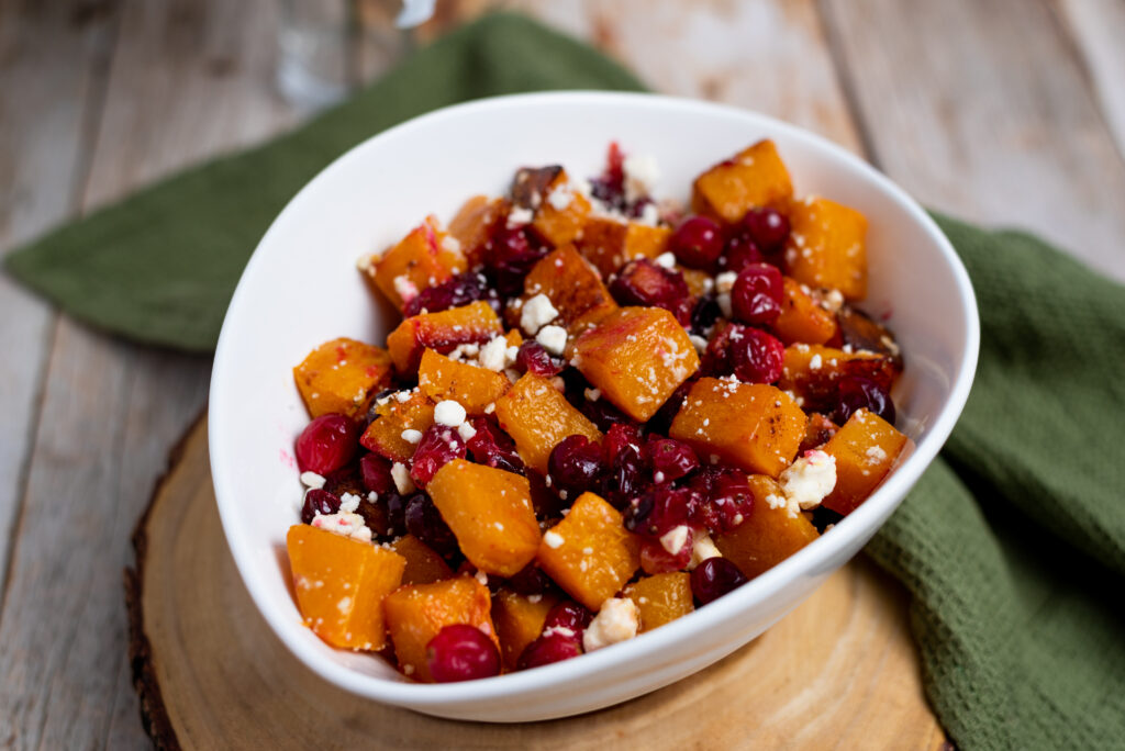 bowl of oven roasted butternut squash with cranberries and feta cheese