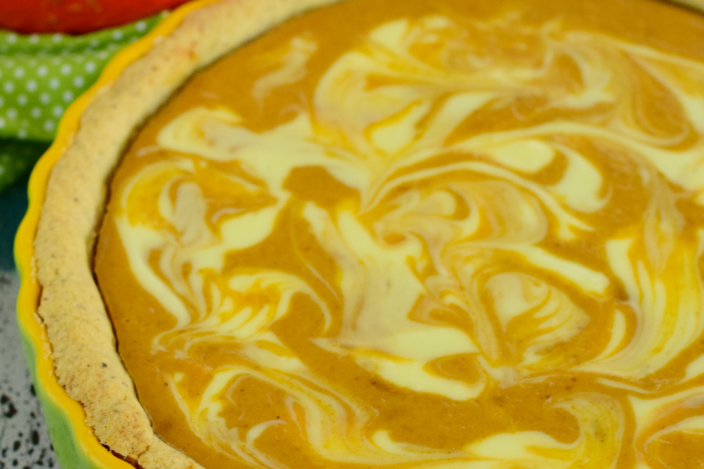 Pumpkin pie with cream cheese swirl in yellow and green pie dish