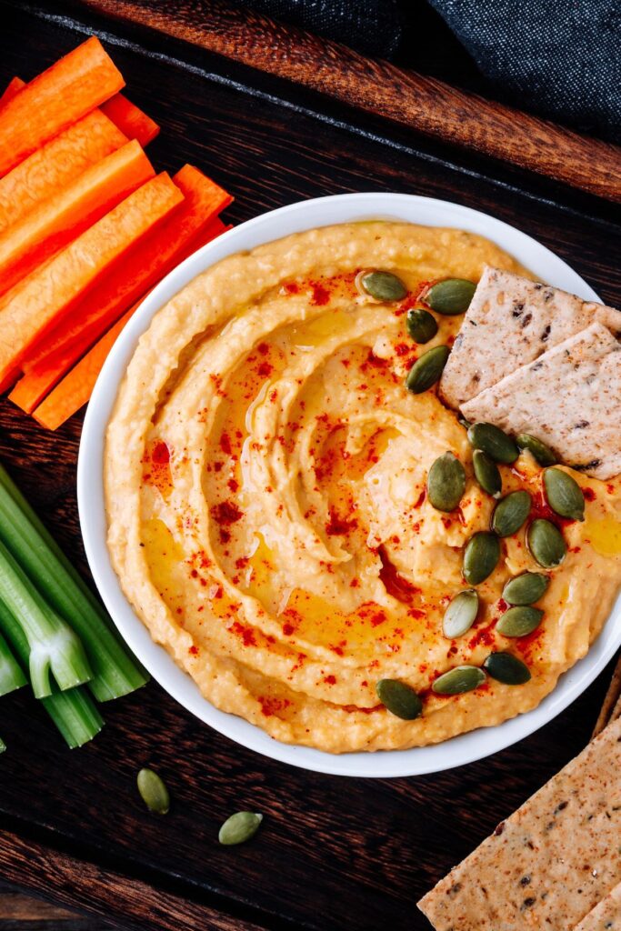 Bowl of dip with vegetables and crackers