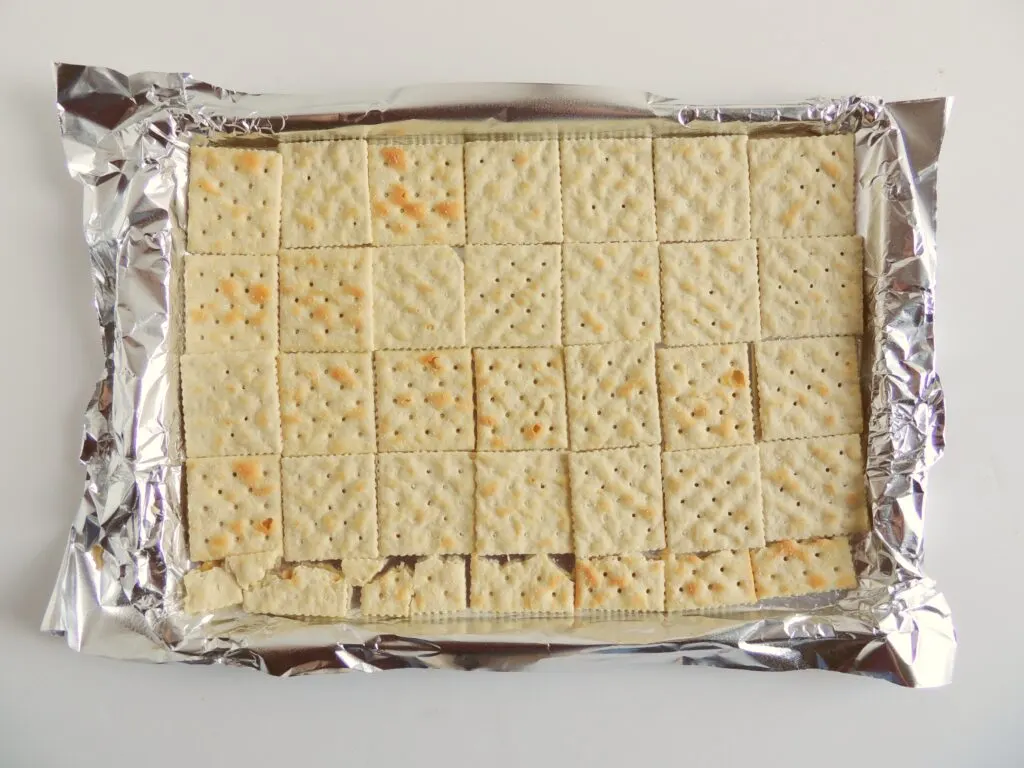 Toffee Saltine Cracker Candy Step 1 - lay out saltines on foil lined baking sheet