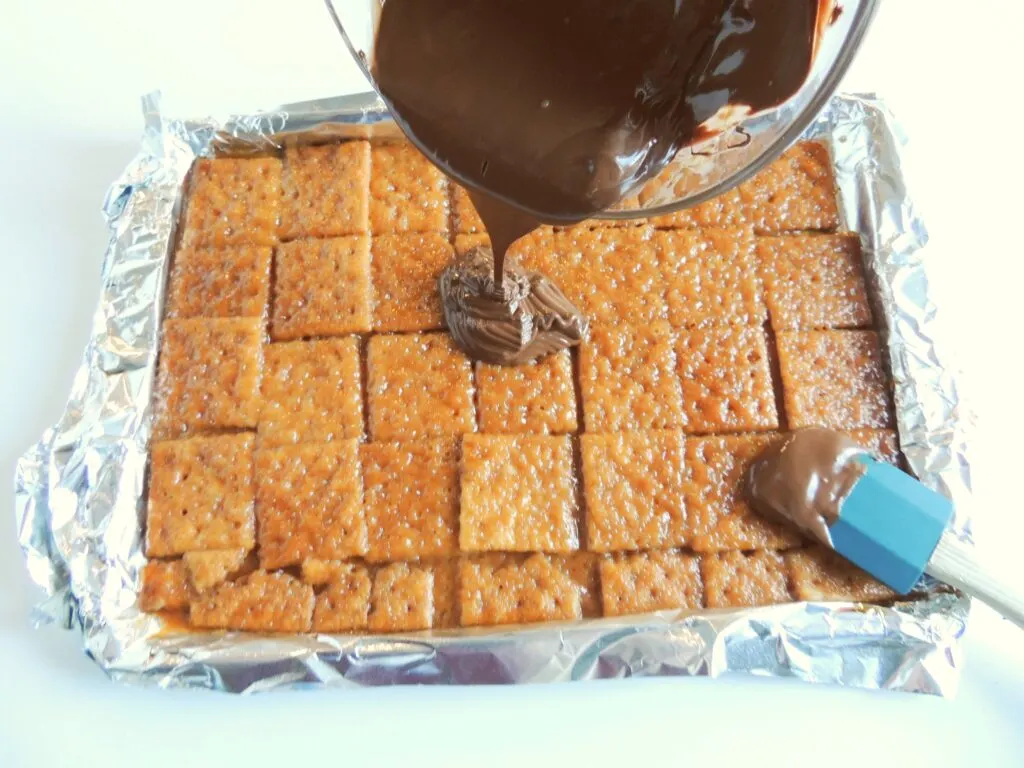 Pour melted chocolate over caramel layer of crackers