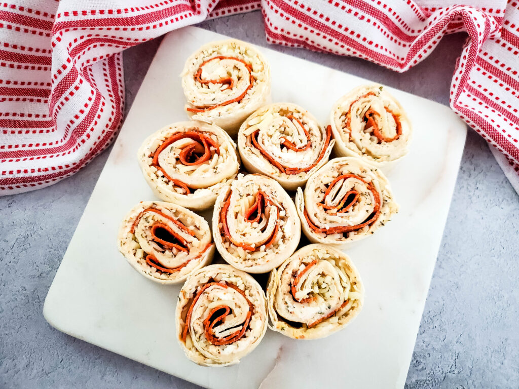 Square white plate with pepperoni pizza appetizer pinwheels