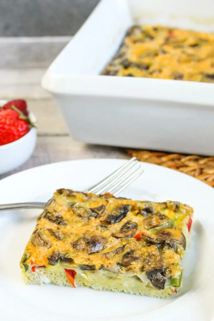 piece of vegetable breakfast casserole on white plate with fork