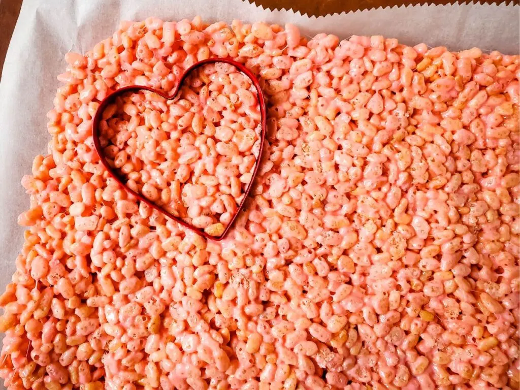 using heart cookie cutter on pink rice crispy treats