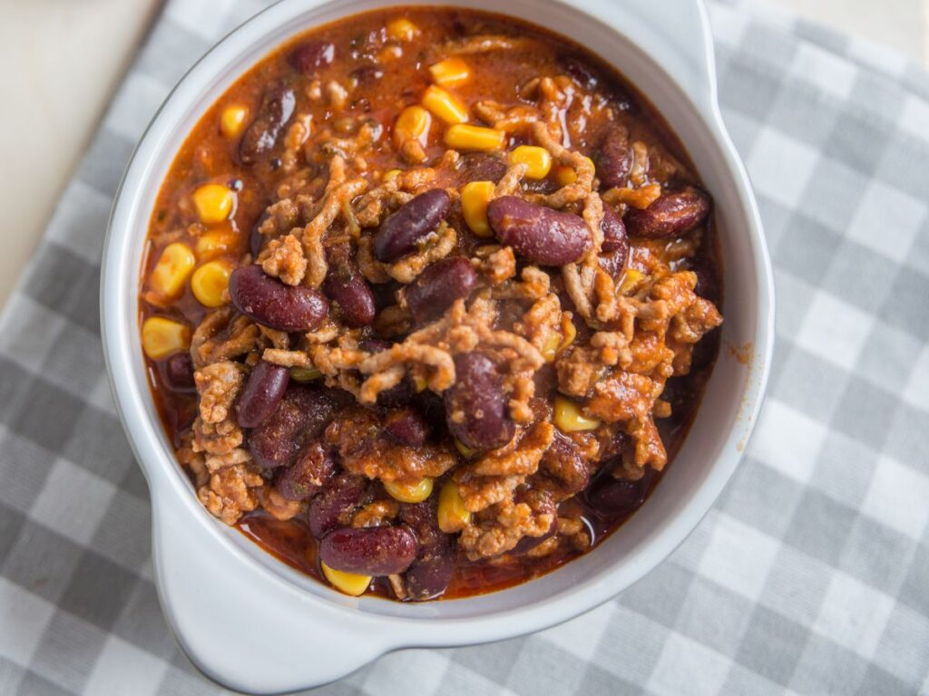 chili con carne in white bowl - cheap family meals using ground beef