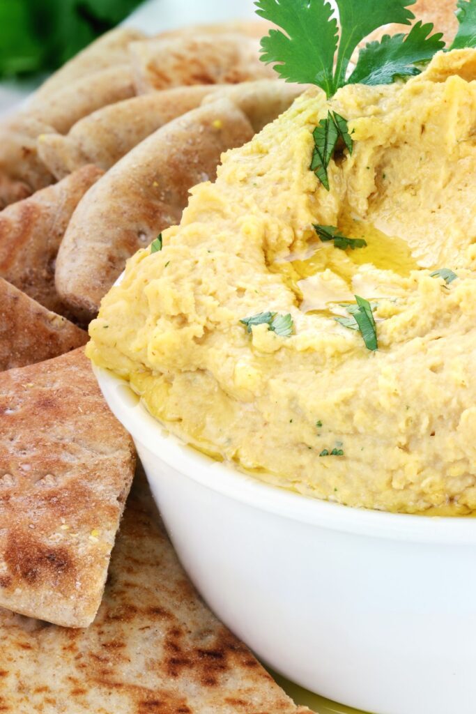 hummus in white bowl with pita chips