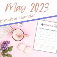 Printed May calendar for 2023 on pink desktop with keyboard and coffee