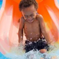 Little boy on orange water slide