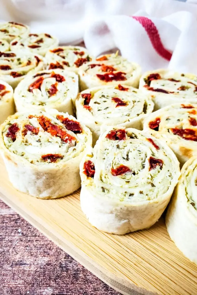 pesto and sun dried tomatoes with cream cheese and Parmesan in tortilla rollups